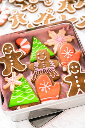 Foto de Embalaje de una variedad casera de galletas de caramelo y pan de jengibre para regalos de comida de Navidad en cajas de lata. - Imagen libre de derechos