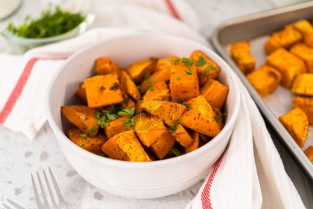 Photo for Serving oven-roasted sweet potatoes in a white ceramic bowl. - Royalty Free Image
