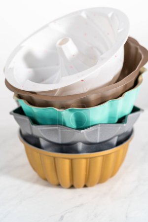Téléchargez les photos : Empilement de différentes couleurs et formes casseroles à gâteau bundt. - en image libre de droit