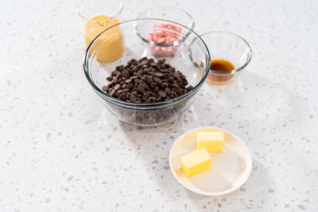 Foto de Ingredientes medidos en cuencos mezcladores de vidrio para hacer caramelo de menta cortador de galletas de Navidad. - Imagen libre de derechos