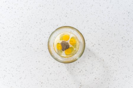 Téléchargez les photos : Pose plate. Mélanger les ingrédients dans un bol à mélanger en verre pour préparer le remplissage pour le petit déjeuner empanadas avec des œufs et de la patate douce. - en image libre de droit