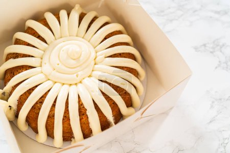 Photo for The Carrot Bundt Cake is carefully packaged into a white paper bundt cake box, ready for gifting or sharing. - Royalty Free Image