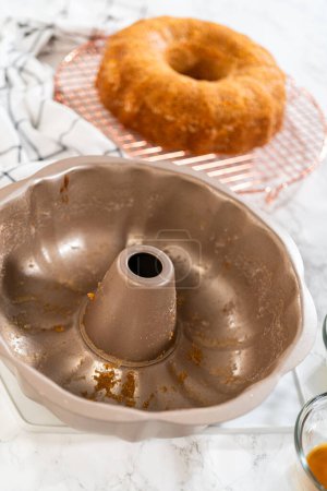 Téléchargez les photos : Le gâteau Bundt aux carottes fraîchement cuit est laissé refroidir sur le comptoir de la cuisine, remplissant l'air d'arômes délicieux. - en image libre de droit