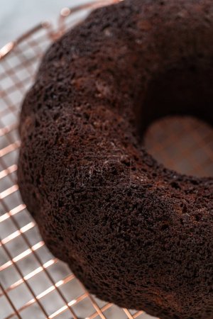 Photo for With precision, the Chocolate Bundt Cake is carefully removed from the pan - placed onto a round cooling rack, preparing it for a flawless presentation and delightful indulgence. - Royalty Free Image