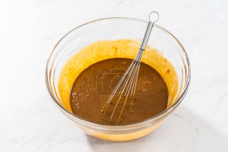 Foto de Mezclar ingredientes húmedos en un tazón de vidrio pequeño para hornear torta de pan de jengibre con relleno de caramelo - Imagen libre de derechos