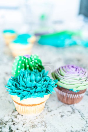 Photo for Using buttercream frosting, vanilla and chocolate cupcakes are intricately decorated to resemble various types of cactuses, creating a delightful and visually engaging dessert that showcases - Royalty Free Image