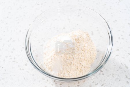 Foto de Mezclar ingredientes secos con un batidor de mano en un tazón grande para hornear cupcakes dulces de leche. - Imagen libre de derechos