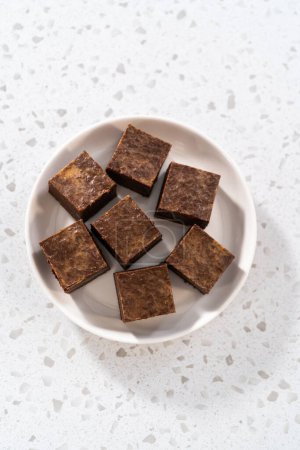 Photo for Homemade chocolate peanut butter fudge pieces on a white ceramic plate. - Royalty Free Image