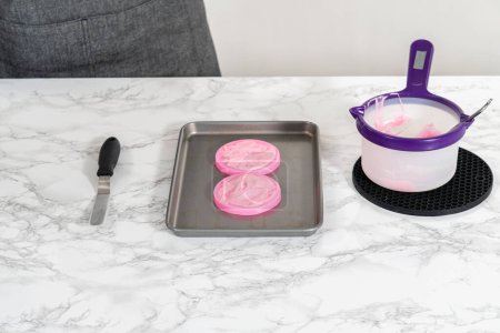 Foto de Preparación de arcos de chocolate rosa para decorar galletas de shortbread en forma de panda. - Imagen libre de derechos