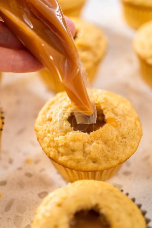 Photo for Filling cupcakes with caramel to make dulce de leche cupcakes. - Royalty Free Image