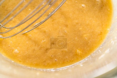 Photo for Mixing wet ingredients in a small glass mixing bowl to bake banana cookies with chocolate drizzle. - Royalty Free Image