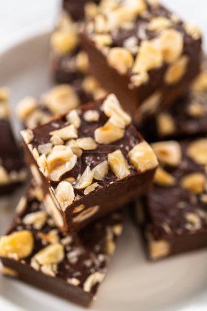 Photo for Homemade chocolate hazelnut fudge square pieces on a white plate. - Royalty Free Image