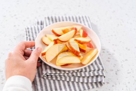 Photo for Thinly sliced red apples on a white plate. - Royalty Free Image