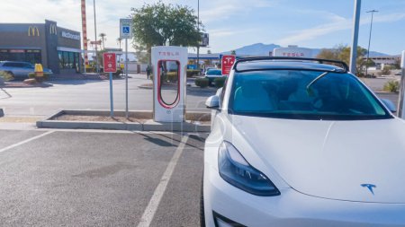 Foto de Primm, Nevada, USA-December 3, 2022-Durante el día, un vehículo Tesla se ve cargando en una estación de sobrecarga Tesla, utilizando la infraestructura de carga de alta velocidad para conveniente y eficiente - Imagen libre de derechos