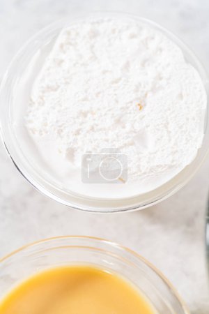 Téléchargez les photos : Measured ingredients in glass mixing bowls to make eggnog fudge. - en image libre de droit