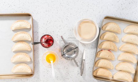 Téléchargez les photos : Pose plate. Remplissage de pâte empanada avec garniture tarte cerise pour faire des empanadas cerise douce dans la friteuse à air. - en image libre de droit