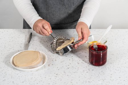 Foto de Relleno de masa de empanada con relleno de pastel de cereza para hacer empanadas de cereza dulce en la freidora. - Imagen libre de derechos