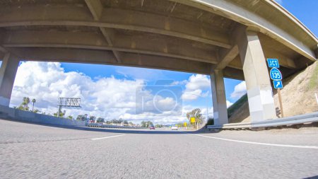 Foto de Santa Maria, California, USA-December 6, 2022-En un día claro de invierno, un automóvil viaja suavemente a lo largo de la autopista 101 cerca de Santa Maria, California, bajo un cielo azul brillante, rodeado por una mezcla de - Imagen libre de derechos