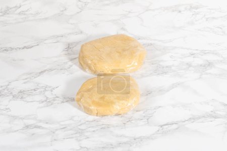 Photo for Wrapping cookie dough into cellophane wrap to transfer into the refrigerator for chilling. - Royalty Free Image