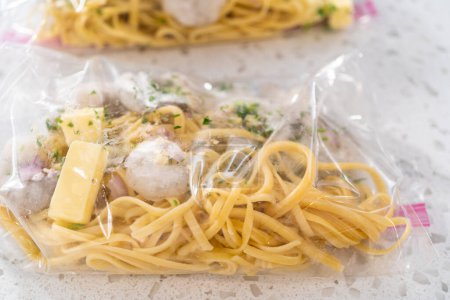 Packaging homemade frozen shrimp scampi meal prep into plastic resealable bags.