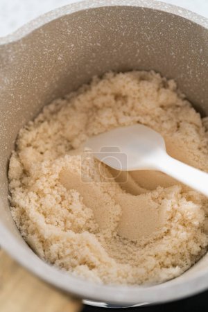 Photo for Caramelizing sugar in a saucepan to make caramel cupcake toppers. - Royalty Free Image