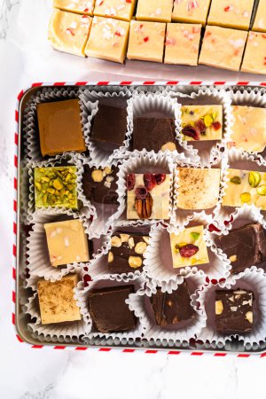 Photo for Packaging a homemade variety of fudge for Christmas food gifts into tin boxes. - Royalty Free Image