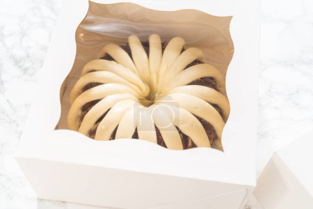 Téléchargez les photos : Les gâteaux bundt fraîchement cuits sont soigneusement nichés dans des boîtes en papier blanc, les préparant pour un transport sûr tout en conservant leur apparence délectable. - en image libre de droit