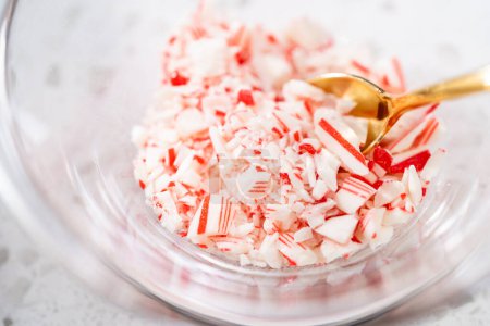 Photo for Measured ingredients in glass mixing bowls to make candy cane chocolate-covered pretzel rods. - Royalty Free Image