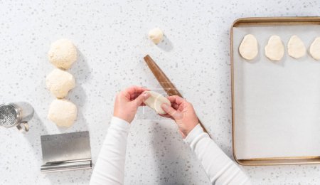 Téléchargez les photos : Pose plate. Rouler la pâte à pain avec un rouleau à pâtisserie français pour cuire les trempettes naan. - en image libre de droit