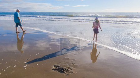 Photo for In California, a father and daughter share a serene winter walk along the deserted sands of El Capitan State Beach. - Royalty Free Image