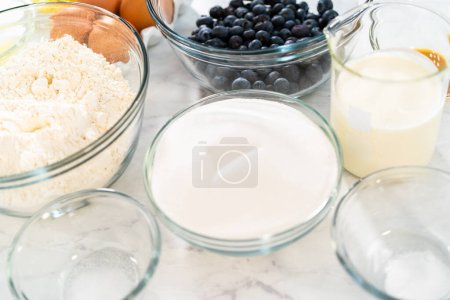 Foto de Ingredientes medidos en cuencos de vidrio para hornear pastel de limonada de arándanos. - Imagen libre de derechos