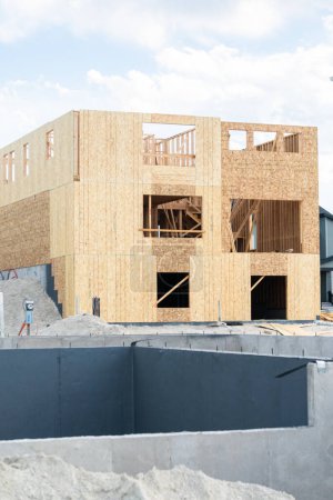 Foto de Un sitio de construcción en curso en los suburbios, con la etapa de fundación de una casa unifamiliar. - Imagen libre de derechos