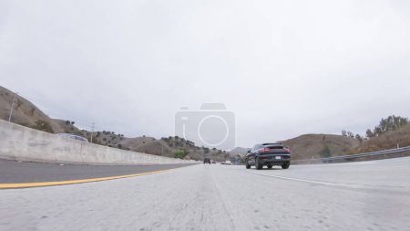 Téléchargez les photos : Los Angeles, Californie, États-Unis-4 décembre 2022-POV-Au milieu d'une journée pluvieuse d'hiver, conduite sur la route 134 près de Los Angeles, Californie, capture l'atmosphère à travers des lentilles recouvertes de gouttes de pluie, ajoutant un unique - en image libre de droit