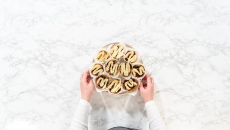 Photo for Flat lay. Freshly baked no-yeast cinnamon roll cupcakes filled with cinnamon filling and chopped pecans. - Royalty Free Image