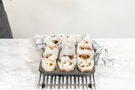Photo for Garnishing no-yeast cinnamon roll cupcakes with cream cheese frosting from the piping bag. - Royalty Free Image