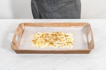 Photo for Spreading unsalted butter at room temperature to prepare a vegetarian party butter board for a party. - Royalty Free Image