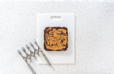 Photo for Flat lay. Scoring chocolate fudge with peanut butter swirl for cutting into small pieces. - Royalty Free Image