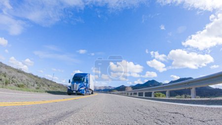 Foto de Santa Maria, California, USA-6 de diciembre de 2022-El vehículo está navegando a lo largo de la autopista Cuyama bajo el sol brillante. El paisaje circundante está iluminado por el sol radiante, creando una - Imagen libre de derechos