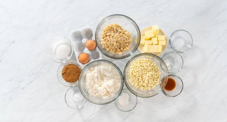 Photo for Flat lay. Measured ingredients in glass mixing bowls to prepare white chocolate macadamia nut. - Royalty Free Image