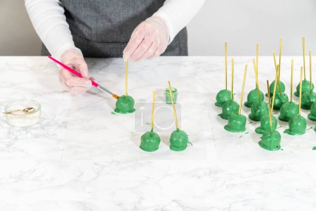 Photo for Decorating cactus cake pops with luster dust, sugar glower, and white sprinkles for the Cinco de Mayo celebration. - Royalty Free Image