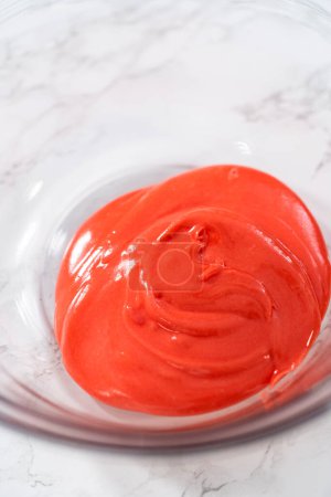 Photo for Mixing ingredients in a large glass mixing bowl to make homemade royal icing. - Royalty Free Image