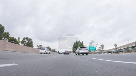 Foto de Los Angeles, California, USA-December 4, 2022-POV-En medio de un día lluvioso de invierno, conduciendo en HWY 134 cerca de Los Ángeles, California, captura la atmósfera a través de lentes cubiertas por gotas de lluvia, agregando un único - Imagen libre de derechos