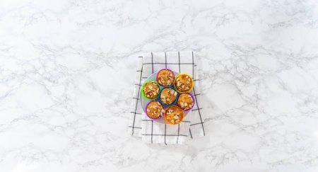 Photo for Flat lay. Freshly baked lemon poppy seed muffins garnished with almond slivers on the kitchen counter. - Royalty Free Image