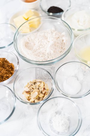 Téléchargez les photos : Ingrédients mesurés dans des bols à mélanger en verre pour cuire des muffins de graines de pavot citron. - en image libre de droit
