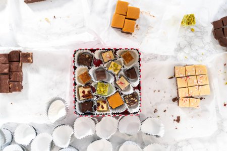 Téléchargez les photos : Pose plate. Emballage d'une variété de caramel maison pour cadeaux alimentaires de Noël dans des boîtes d'étain. - en image libre de droit