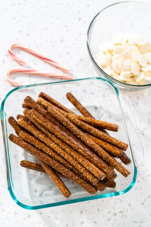 Foto de Ingredientes medidos en cuencos de vidrio para hacer barras de pretzel cubiertas de chocolate con caña de caramelo. - Imagen libre de derechos