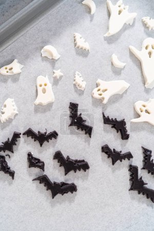 Foto de Llenado de molde de silicona de Halloween con chocolate derretido para hacer decoración de chocolate para pretzels. - Imagen libre de derechos
