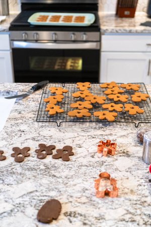 Foto de En una cocina blanca contemporánea, masa de galletas de jengibre es hábil - Imagen libre de derechos