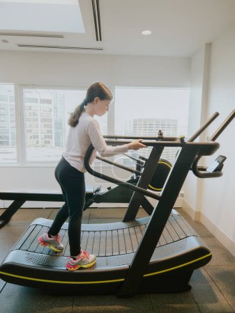 Photo for A dedicated young athlete giving her all, running on a treadmill in the gym. - Royalty Free Image