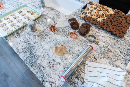 Photo for In a contemporary white kitchen, gingerbread cookie dough is skillfully rolled out, setting the stage for a delightful holiday treat. - Royalty Free Image